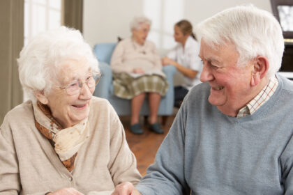 Two elderly people chatting and laughing