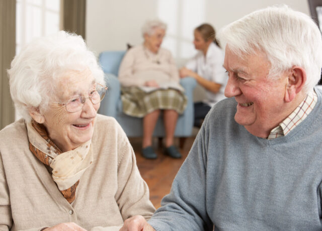 Two elderly people chatting and laughing
