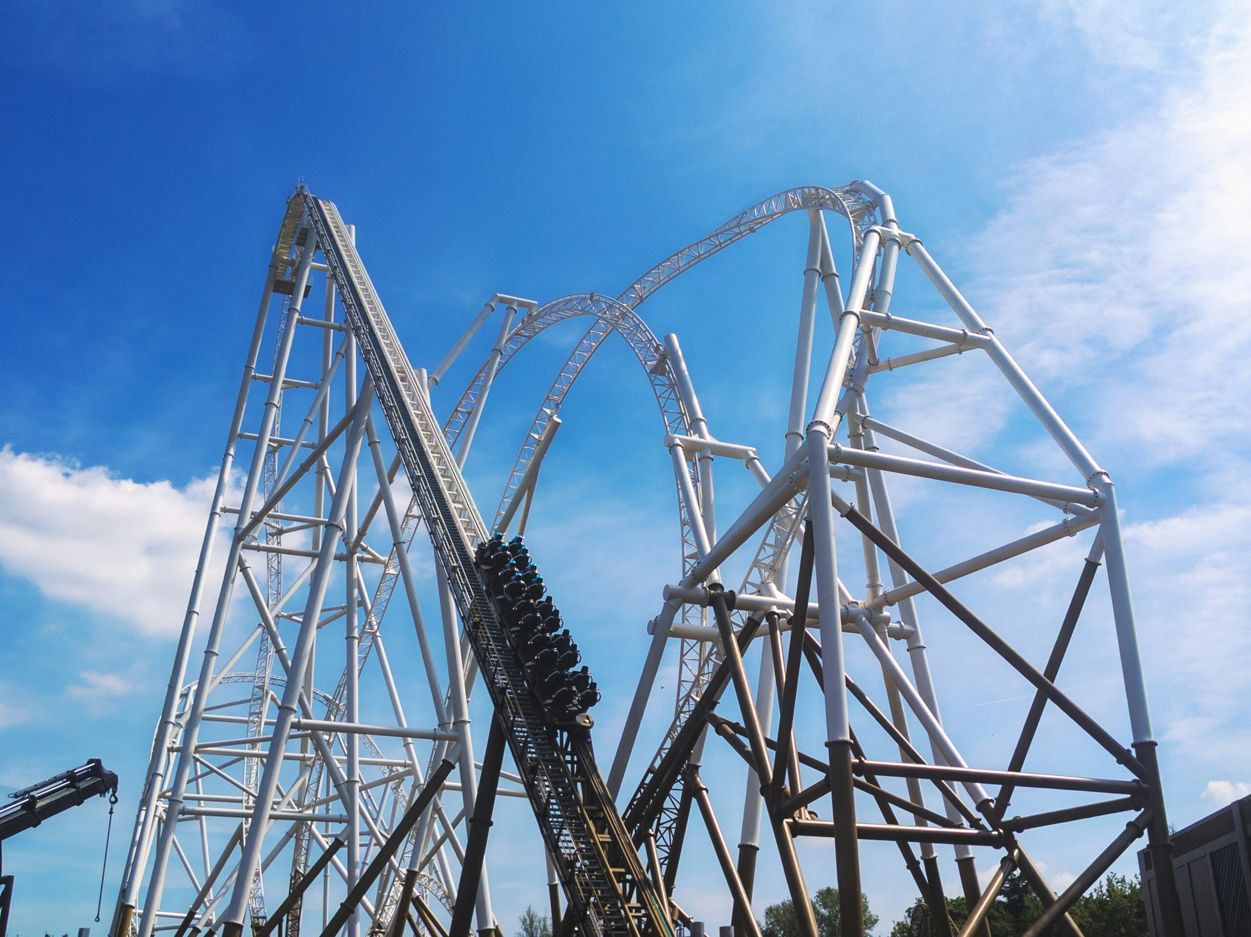 The Stealth roller coaster at Thorpe Park, with a steep incline and towering white steel structure under a bright blue sky.