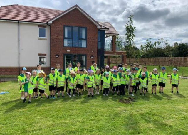 Local schoolchildren wearing high-visibility vests during an outdoor visit to Humberston House Care Home.